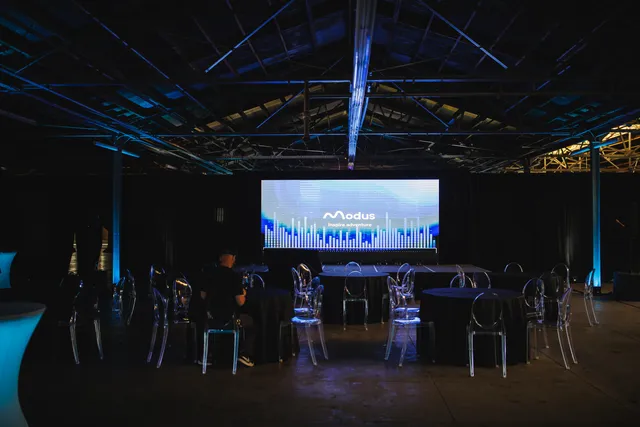 Gala stage and projection screen set in the darkened warehouse