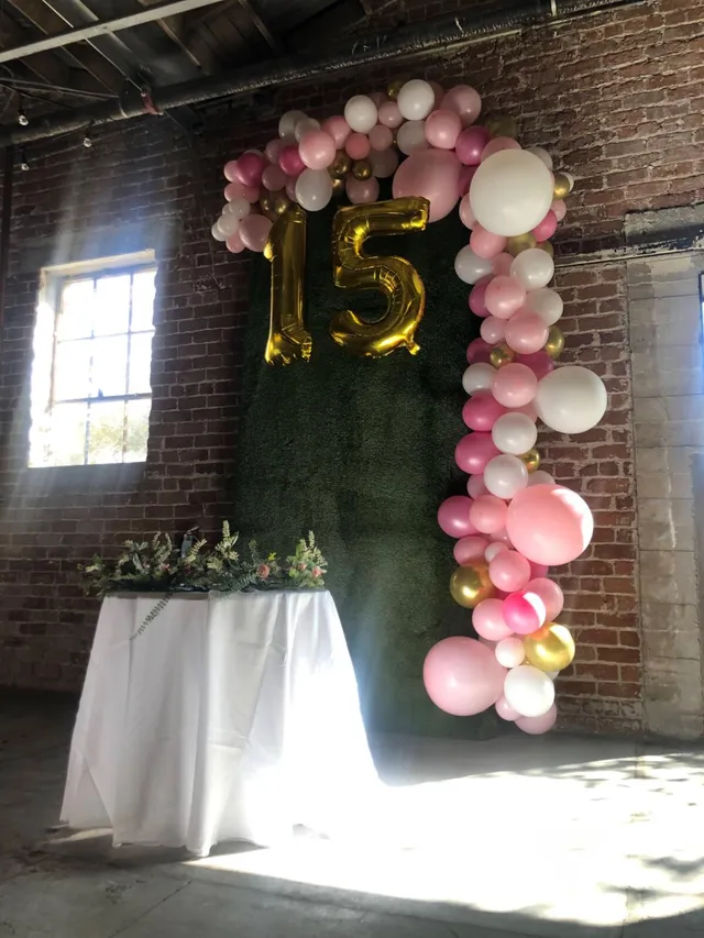 Quinceañera balloon arch in pink and gold with a 15 marquee